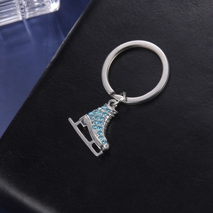Gros plan du porte-clés patin à roulettes avec strass bleu clair sur fond de cuir noir