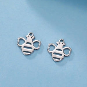 Macro shot of two silver honeybee charms with hollow wings made of polished stainless steel