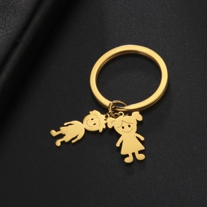 Detail of gold-plated stainless steel keychain with cute boy and girl cartoon charms