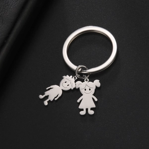 Detailed view of stainless steel boy and girl charms on a polished keyring on dark background