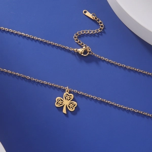 Detail of golden clover pendant necklace with Celtic knot cut-outs and lobster clasp