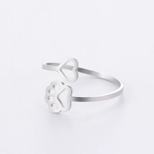 Detailed macro view of open adjustable ring with paw print and heart cutout patterns