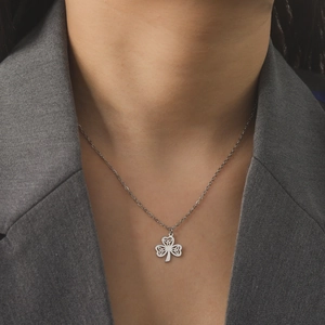 Silver Celtic knot clover pendant necklace shown on a model wearing a grey blazer