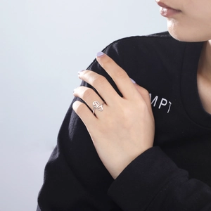 Macro shot of silver open ring with hollow heart and paw print design on finger
