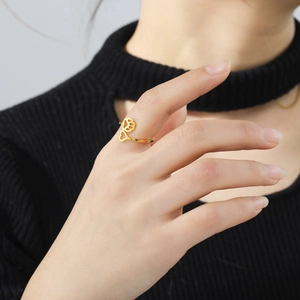 Golden open ring with hollow heart and paw print pattern on model's hand