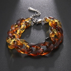 Dettaglio del bracciale a catena spessa in acrilico ambra con chiusura a moschettone argento