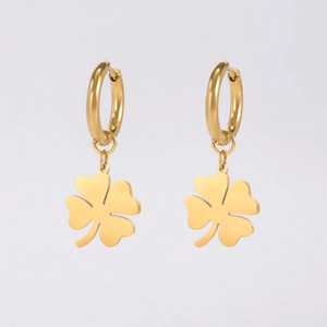 Detalle de pendientes de aro en acero inoxidable dorado con dije de trébol
