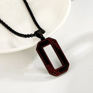 Gros plan du pendentif octogonal noir avec coutures de baseball rouges sur une chaîne