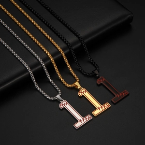 Détail macro de pendentifs numéro 1 avec coutures de baseball en argent, or et noir poli