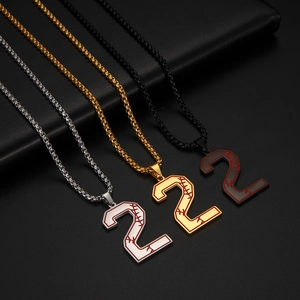 Détail des pendentifs numéro 2 en argent or et noir avec motifs de couture de baseball