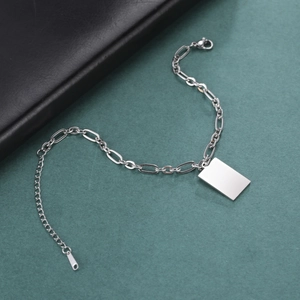 Macro-opname van zilveren hip-hop ketting met gepolijst rechthoekig label op groene achtergrond