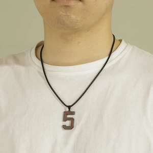 Gros plan du collier pendentif numéro 5 en métal gris avec une chaîne à billes noire
