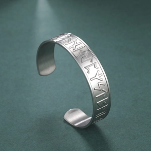 Macro detail of Nordic Runes engraved on a vintage silver titanium steel bangle