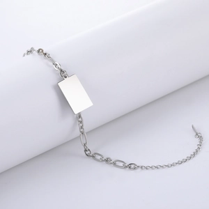 Detail van zilveren titanium stalen armband met lange rechthoekige graveerplaat en ketting
