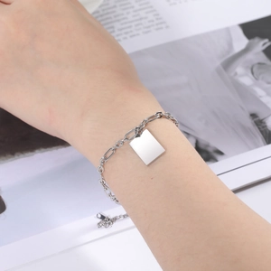Minimalistische stalen kettingarmband met rechthoekige hanger om de pols gedragen