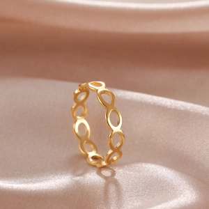 Dettaglio macro dell'anello infinito in oro su un elegante sfondo di seta