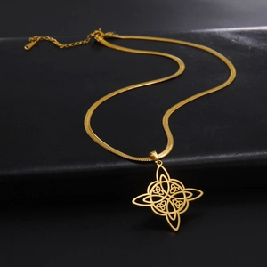 Nahaufnahme des goldenen Hexenknoten-Anhängers an einer flachen Schlangenkette aus Metall