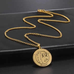 Gros plan du collier signe du zodiaque Gémeaux doré sur texture cuir noir