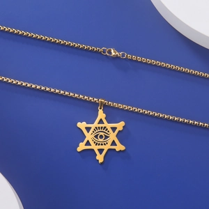 Détail du collier hexagramme doré avec pendentif œil de la providence sur fond bleu foncé