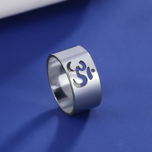 Macro shot of silver stainless steel ring with hollowed Om symbol on blue background