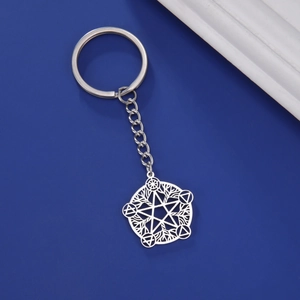Macro shot of silver stainless steel keychain with hollow star and alchemy symbol pendant