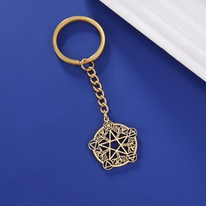 Close-up of golden stainless steel keychain with hollow star and tree symbol pendant