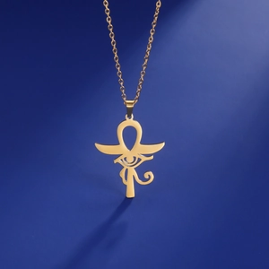 Gros plan du pendentif doré Œil d'Horus et Croix d'Ankh avec texture métallique riche