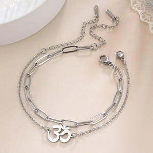 Detail of silver double-layered stainless steel bracelet with OM symbol and clip chain