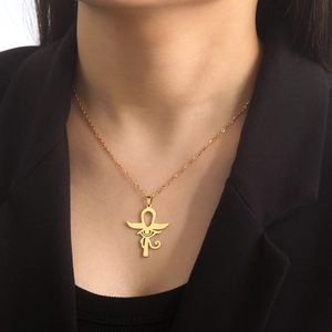 Pendentif Ankh et Œil d'Horus doré sur chaîne en acier porté avec un costume noir chic