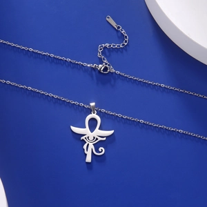 Détail du pendentif Ankh et Œil d'Horus sur un fond plat de couleur bleu foncé