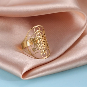 Eleganter goldener Edelstahlring mit hohl-hexagramm auf feinem Seidenstoff-Hintergrund