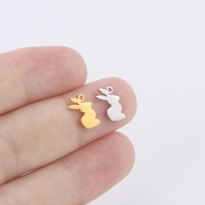 Pendentifs lapin en or 18 carats et argent pour bijoux DIY, présentés sur un doigt