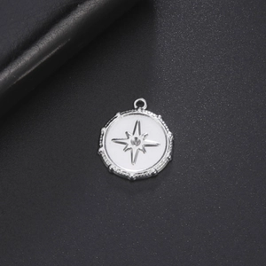 Stainless steel round pendant with embossed compass star and textured edge details