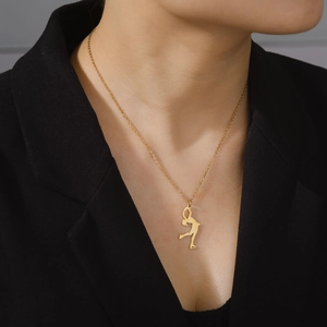 Polished gold gymnast silhouette pendant on a minimalist stainless steel chain necklace