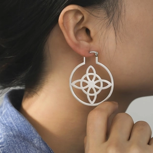 Large silver stainless steel hoop earrings with intricate geometric hollow witch knot design