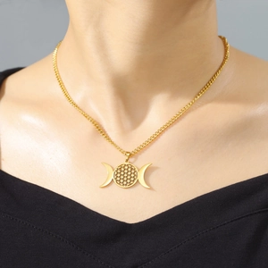 Detalle del collar dorado de triple luna y flor de la vida en una modelo mujer