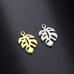 Detailed view of hollow monstera leaf pendants in gold and silver stainless steel