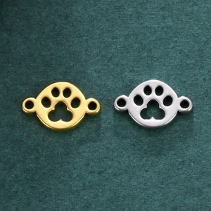 Macro detail of paw print jewelry pendants in gold and silver stainless steel finish