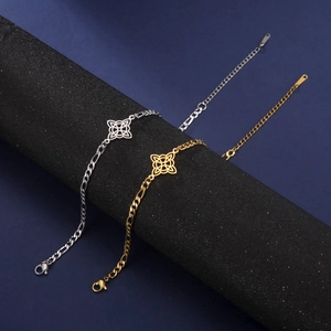 Detailed view of gold and silver Figaro chain bracelets with Celtic knot flower charms