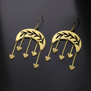 Detailed view of bohemian gold crescent moon earrings with wheat ears and heart pendants