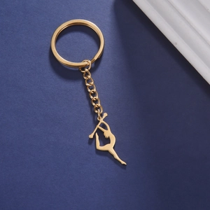 Détail d'un porte-clés doré avec silhouette de gymnastique sur fond bleu texturé