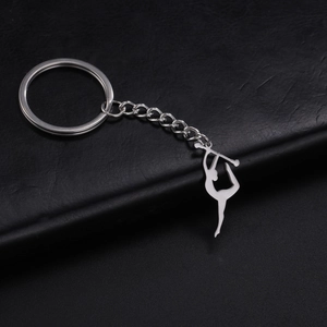 Porte-clés gymnaste en acier inoxydable poli sur surface en cuir noir texturé