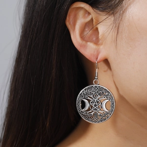Detailopname van retro zilveren oorbellen met Triple Moon en Pentagram in Keltische stijl