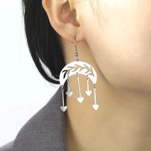 Bohemian silver moon earrings with heart charms and leaf texture worn on a model