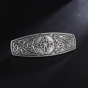 Detail of Celtic knot hair clip with antique silver finish on a black textured surface