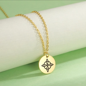 Detalle de collar de acero inoxidable dorado con colgante redondo de nudo de bruja