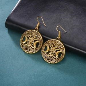 Detail van vintage gouden oorbellen met levensboom, halve maan en stermotieven