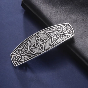 Vintage Celtic knot hair clip with silver alloy finish on dark leather background