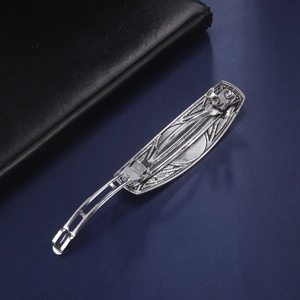 Vintage silver alloy hair clip with embossed texture on dark blue background