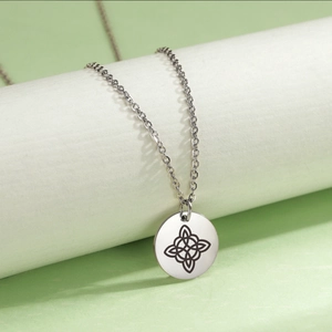 Macro detail of silver stainless steel necklace with laser-etched black Celtic knot pendant